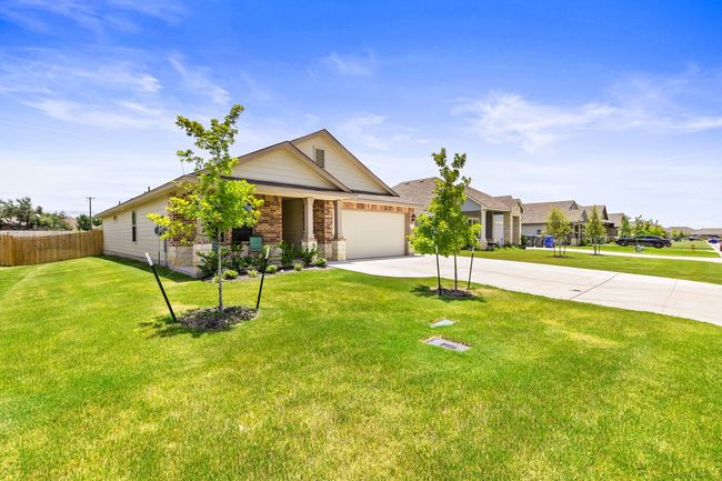 View of front of home with concrete driveway, an attached garage, and brick siding | Image 7