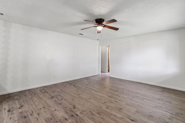 Spare room featuring a ceiling fan and wood finished floors | Image 4