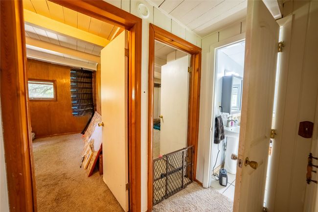 Corridor featuring carpet flooring and wood walls | Image 13