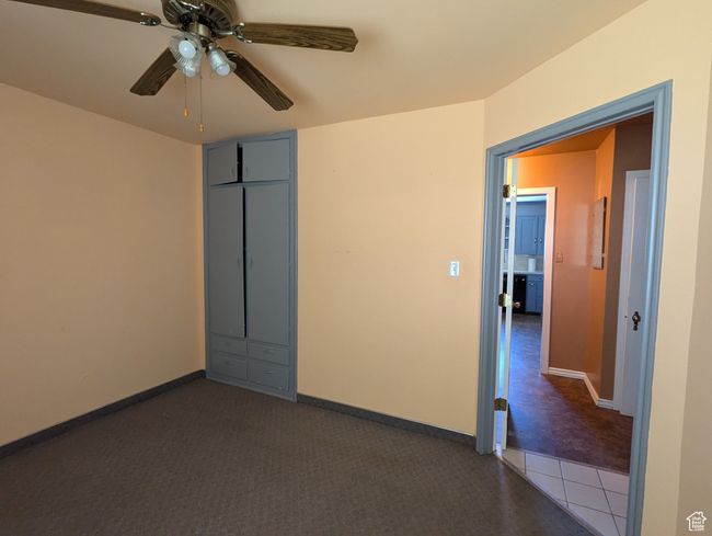 Empty room featuring baseboards, dark colored carpet, and ceiling fan | Image 9