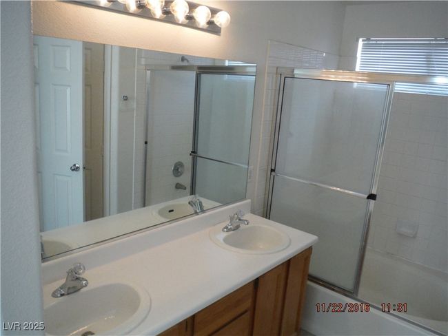 Full bathroom with combined bath / shower with glass door, double vanity, and a sink | Image 7