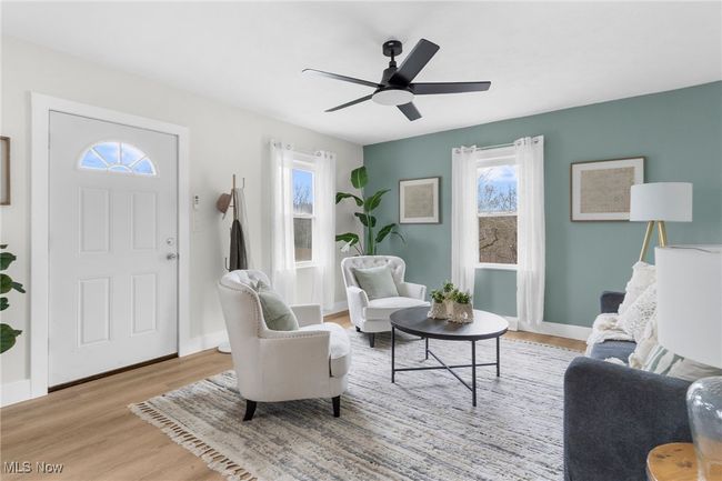 Living room with ceiling fan and light wood-type flooring | Image 4