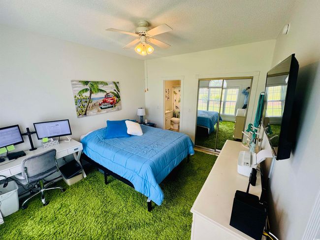 Bedroom featuring carpet, a desk, a closet, a textured ceiling, and ceiling fan | Image 19