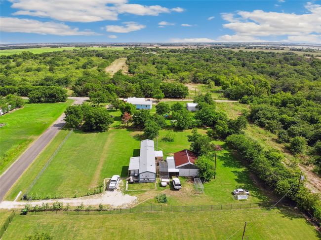 Aerial view of sparsely populated area with a heavily wooded area | Image 4