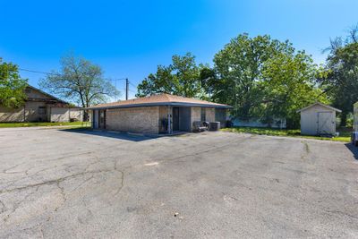 View of side of home with a carport and a storage unit | Image 2