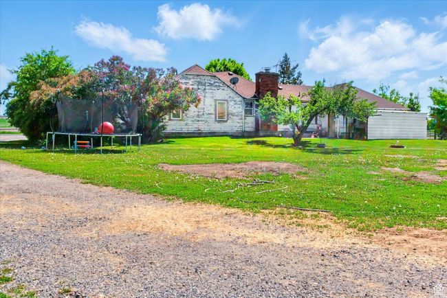 View of front of house with a trampoline, a chimney, and a front lawn | Image 25
