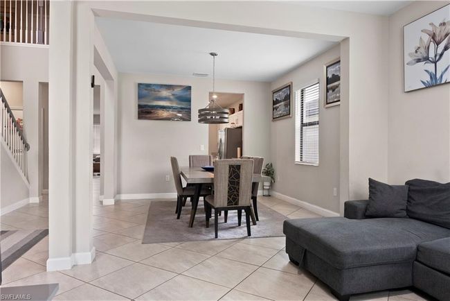 Dining space with light tile patterned flooring, a notable chandelier, stairway, baseboards, and visible vents | Image 8