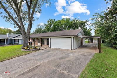 Single story home featuring a front lawn, a garage, and a carport | Image 2