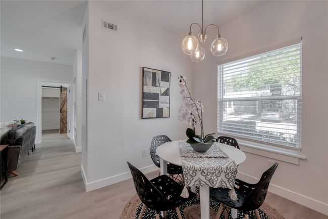 Dining space with light wood finished floors and a chandelier | Image 4