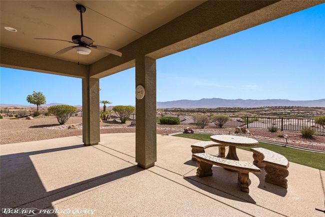 View of patio with fence, a mountain view, and a ceiling fan | Image 51