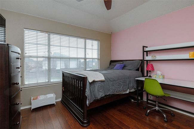Bedroom featuring baseboards, vaulted ceiling, ceiling fan, and hardwood / wood-style flooring | Image 27