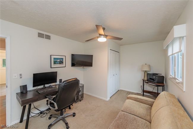 Carpeted office space featuring ceiling fan and a textured ceiling | Image 35