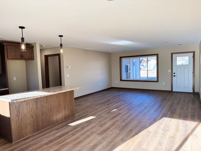 The open concept kitchen, living & dining areas feature vinyl plank flooring for a great look and easy maintenance. | Image 6