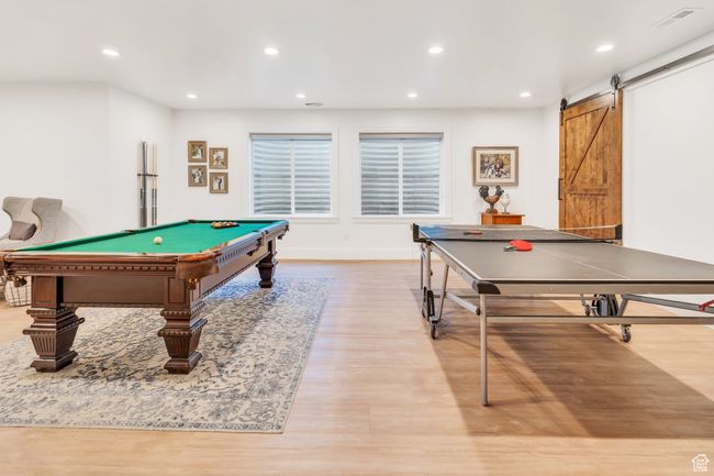 Recreation room with wood finished floors, a barn door, recessed lighting, and billiards | Image 51