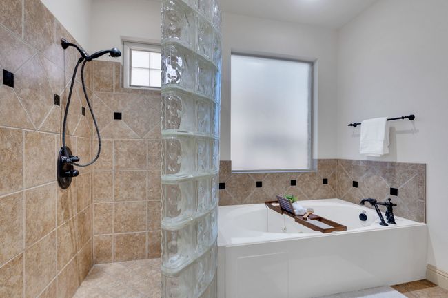 Bathroom featuring a garden tub and a tile shower | Image 20