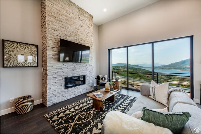 Living room featuring a fireplace, a high ceiling, and hardwood / wood-style flooring | Image 5