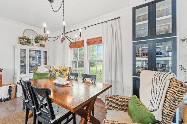 Dining room featuring crown molding, wood finished floors, and a chandelier | Image 11