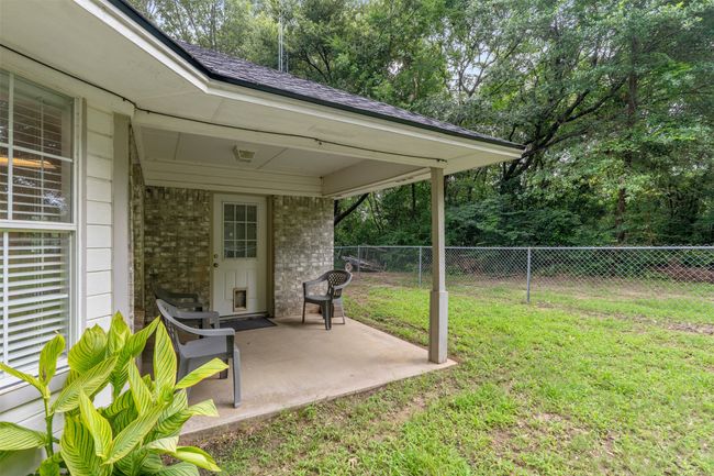 View of yard featuring a patio area and view of wooded area; enjoy winding down in the evenings with this westj-facing view. | Image 25
