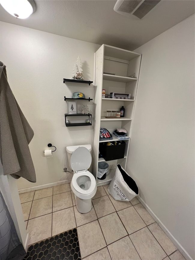 Bathroom with toilet, tile patterned flooring, and baseboards | Image 21