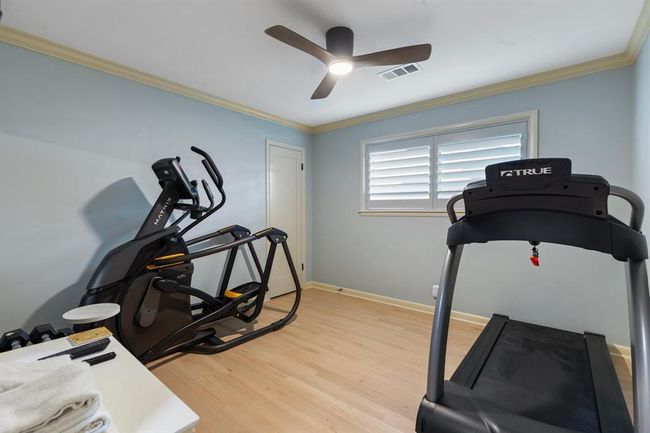 Bedroom # 3 features refinished wood floors, window shutters and modern ceiling fan. | Image 15