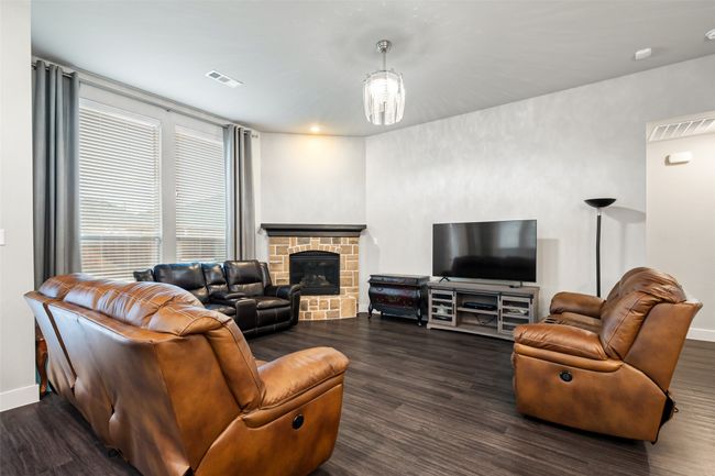 Living room with dark hardwood / wood-style floors, an inviting chandelier, and a fireplace | Image 9