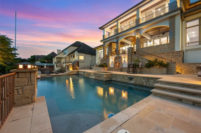 View of swimming pool featuring a patio, stairway, and a pool with connected hot tub | Image 31