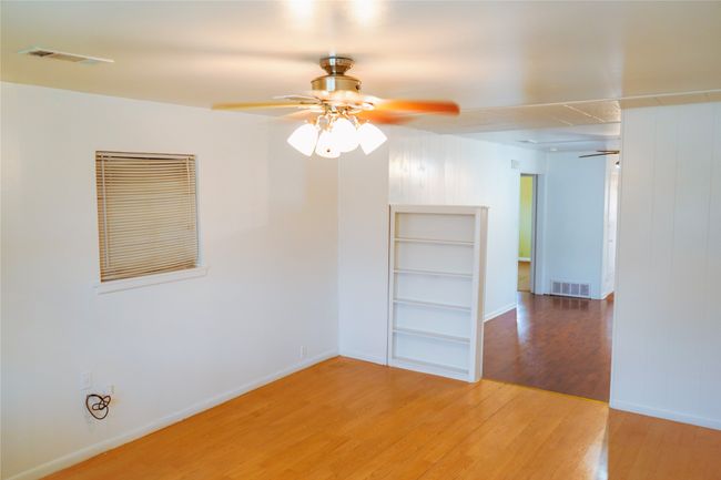 Unfurnished room with wood finished floors, visible vents, and ceiling fan | Image 8