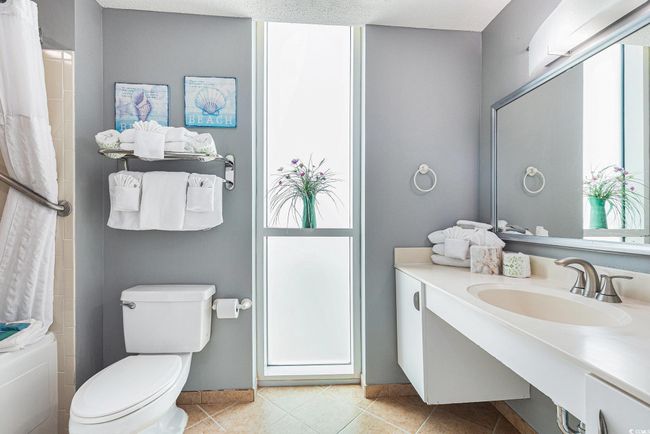 Full bath featuring toilet, tile patterned flooring, a shower with shower curtain, and vanity | Image 17