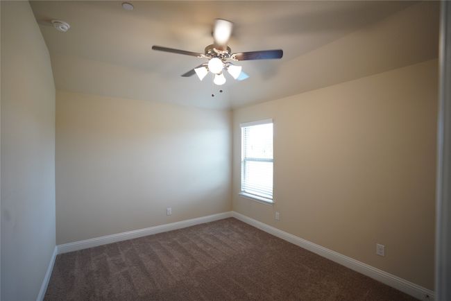Empty room featuring dark colored carpet and a ceiling fan | Image 24