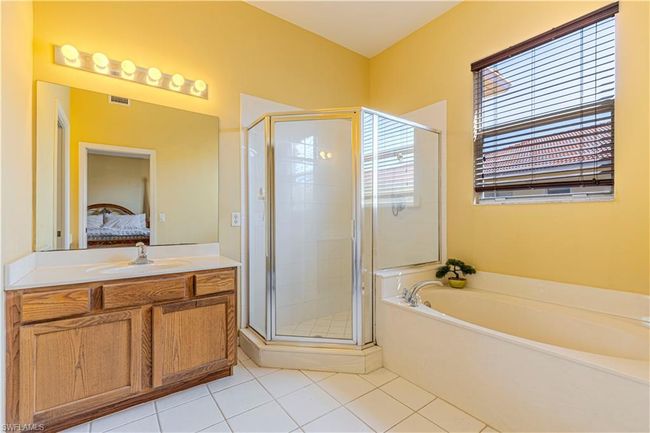 Ensuite bathroom with vanity, tile patterned floors, ensuite bath, a shower stall, and a bath | Image 13