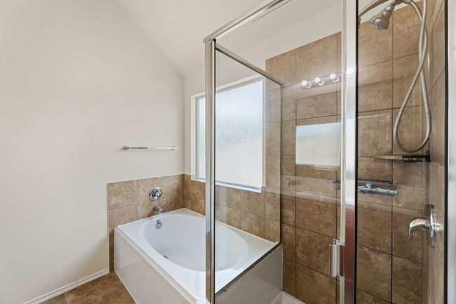 Bathroom with a garden tub, lofted ceiling, a stall shower, and tile patterned flooring | Image 25