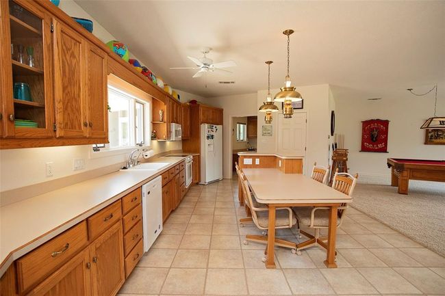 Kitchen featuring a wealth of natural light, light carpet, a center island, and white dishwasher | Image 22