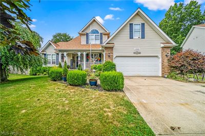 View of front facade featuring a garage, a porch, and a front lawn | Image 1