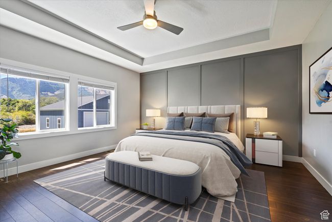 Primary bedroom with a tray ceiling, wood-type flooring, baseboards, and a ceiling fan | Image 30