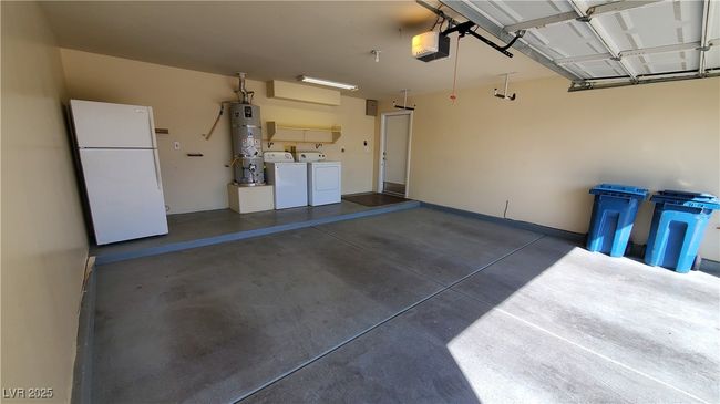 Garage with a garage door opener, strapped water heater, washing machine and clothes dryer, and freestanding refrigerator | Image 27