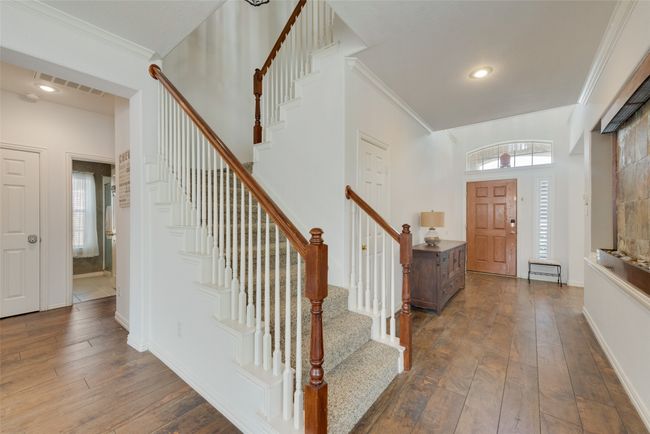 Dining room featuring baseboards, an inviting chandelier, ornamental molding, and wood finished floors | Image 4