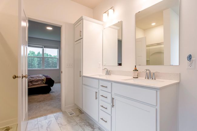 Crisp and modern design connects the bathroom to the primary bedroom, showcasing thoughtful layout and flow. | Image 20