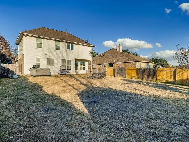 Rear view of property featuring a hot tub and a fenced backyard | Image 25