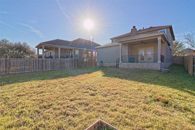 Back of house with a fenced backyard, a ceiling fan, and a chimney | Image 31