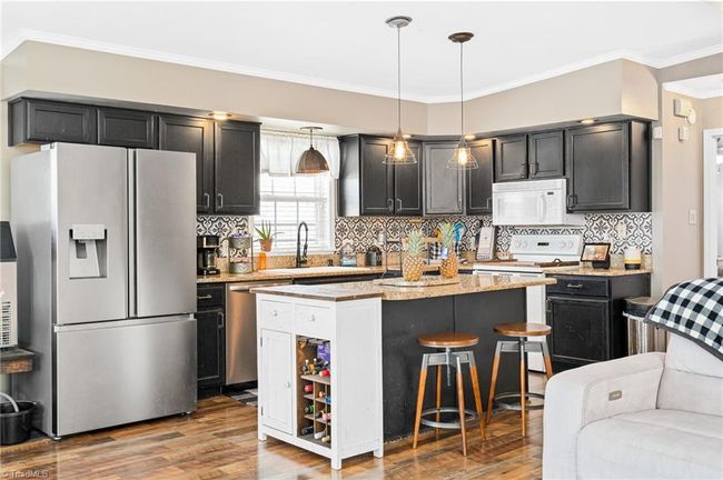 Solid surface countertops, black cabinetry & beautiful backsplash. | Image 11
