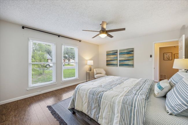 Bedroom with hardwood / wood-style floors, a textured ceiling, and a ceiling fan | Image 16