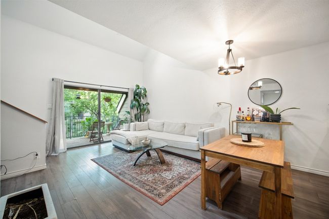 Open Concept Living Room with outdoor balcony and wood floors + vaulted ceilings. | Image 6