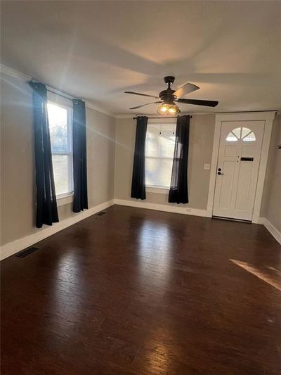 Unfurnished living room featuring dark hardwood / wood-style floors and ceiling fan | Image 2