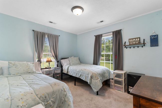 Bedroom with ornamental molding and light carpet | Image 20