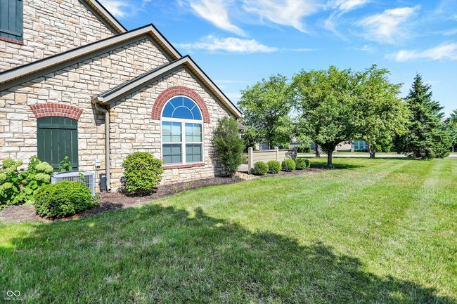 View of the exterior featuring beautiful stone siding and hands free lawn! | Image 30