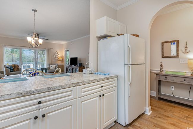 Kitchen featuring crown molding, white cabinets, light hardwood / wood-style floors, and white refrigerator | Image 8