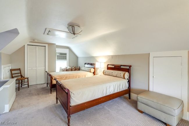 Carpeted bedroom featuring vaulted ceiling, a closet, and a wall unit AC | Image 24