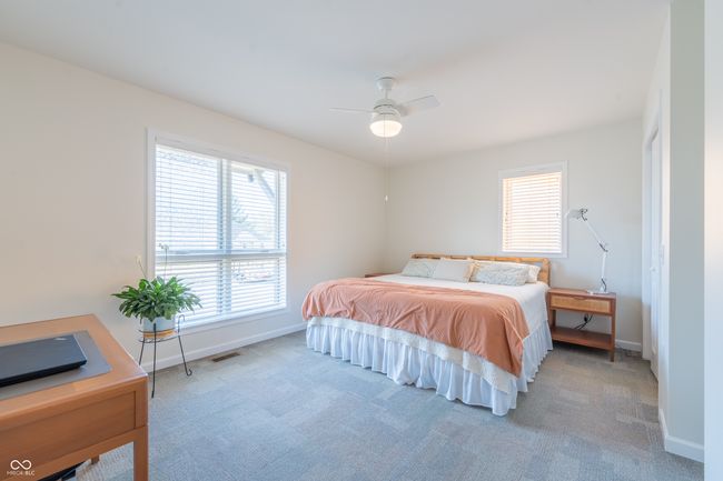 bedroom featuring ceiling fan, baseboards, visible vents, and light carpet | Image 14