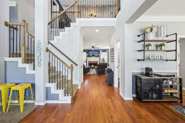View from entry doors. Looking into family room with powder bath nearby, with formal living and dining on either side of entry. Notice the updated stairway balusters! | Image 4