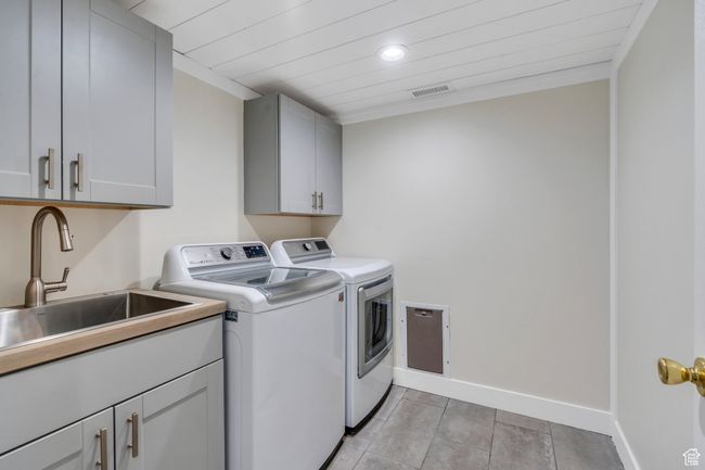 Washroom with washer and dryer, cabinet space, recessed lighting, light tile patterned floors, and wood ceiling | Image 13